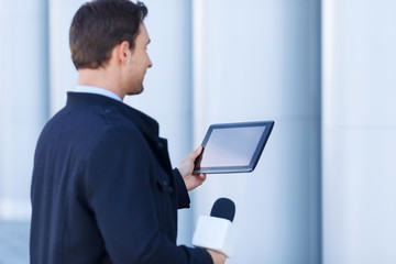 Newshawk is absorbed by information on his tablet.
