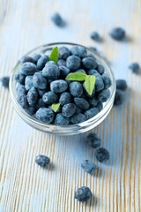 Honeysuckle berries in bowl on wooden surface