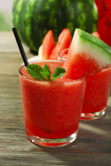 Glasses of watermelon juice on wooden table, closeup