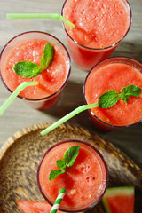 Glasses of watermelon juice on wooden table, top view