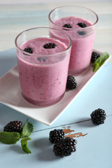 Delicious berry smoothie with blackberries on wooden table close up
