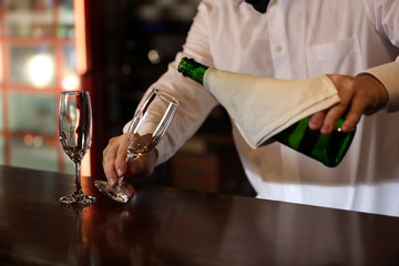 Bartender pouring champagne into glass, close-up