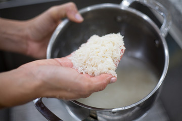 Closeup portrait of hands washing jasmine rice to free from dust and dirt before cooking, isolated background of sink