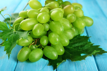 Bunch of white grape on blue wooden background