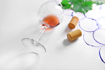 Wine glass and branch of grapes painted with stains of glass on white paper background