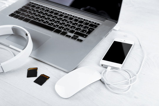 Computer peripherals and laptop accessories on white wooden background