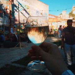 holding a glass of white wine with reflection
