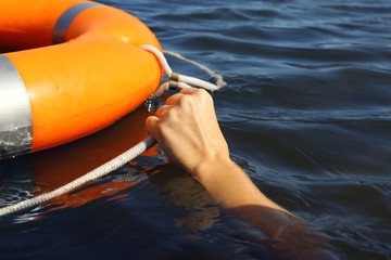 Fototapeta premium Hand holds a cord of a life buoy