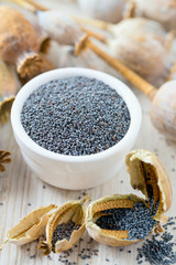 poppy seeds in a bowl on wooden surface