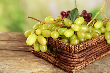 Bunch of white grape in basket  on wooden table