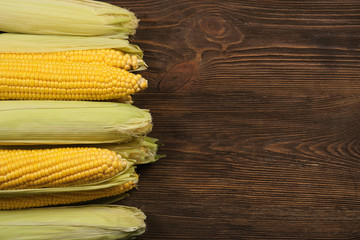 Ripe corn on wooden background