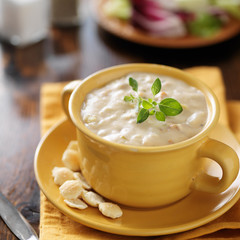 clam chowder in yellow bowl with cackers close up