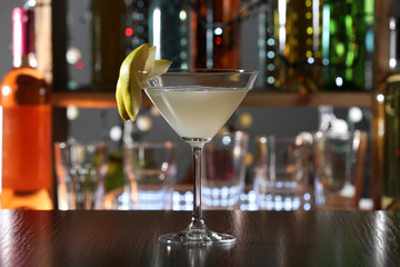 Cocktail decorated with peaces of pear on the bar counter, close up