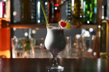 Cocktail decorated with cherry and pineapple on the bar counter, close up
