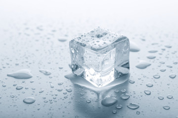 Melting ice cube on grey background