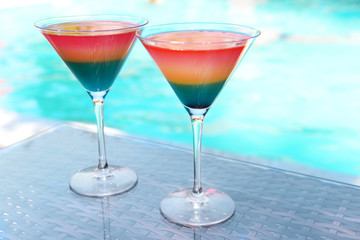 Cocktails on swimming pool background
