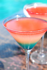 Cocktails on swimming pool background