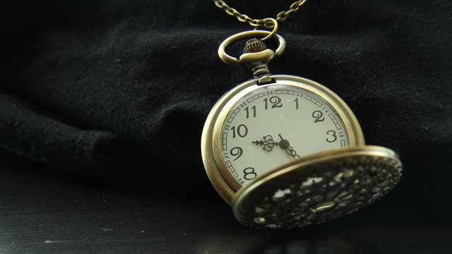 Pocket Watch Time Lapse Ungraded. Antique looking pocket watch on black surface, shot in time lapse. Ungraded version.