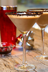Chocolate martini garnished with chocolate powder on the rim and whip cream and sprinkles