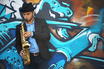 Saxophone player on graffiti wall background