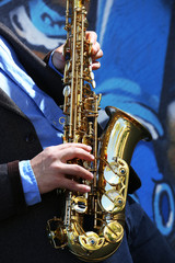 Obraz premium Saxophonist plays jazz on the street, close up