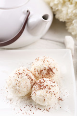 Homemade coco sweets on plate, on light background