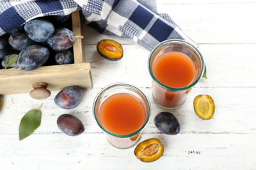 Plum Juice in glasses with fresh fruits