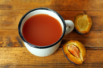 Plum Juice in mug with fresh fruits