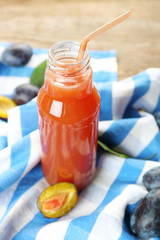Plum Juice in a glass bottle with fresh fruits