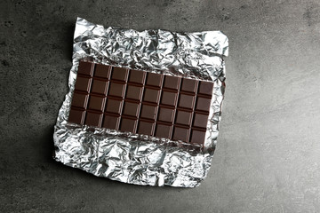 Chocolate bar in foil  on gray background