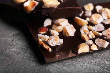 Black chocolate pieces and nuts on dark gray background
