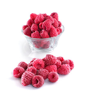 Frozen raspberries in a glass bowl isolated on white background