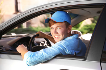 Pizza delivery boy with tablet in car, close-up