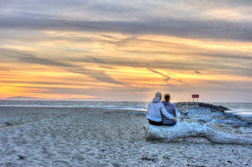 Closer view of man with arm around wife at sunset