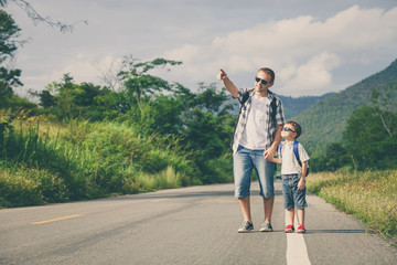 Father and son walking on the road.