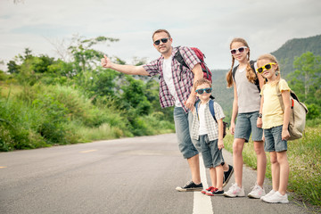 Father and children walking on the road.