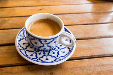 cup of espresso on a wooden background table.