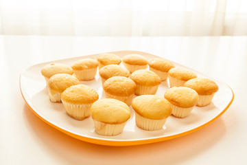 Tasty yellow muffins in a white plate