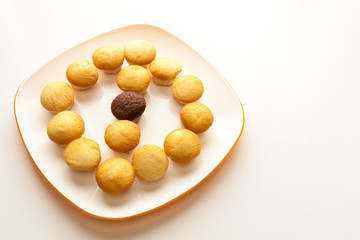 Tasty yellow muffins and chocolate muffin in center