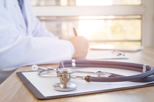Close-up of stethoscope and folder on background of doctors at work