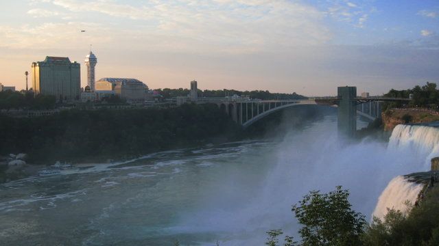 Niagara Falls Sunset Skyline Time-Lapse. Niagara Falls and the Rainbow Bridge that connects the United States to Canada. 