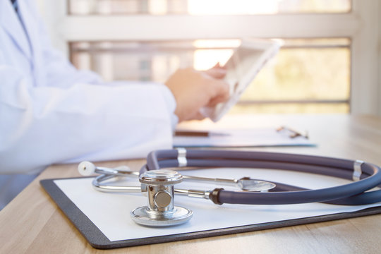 Close-up of stethoscope and folder on background of doctors at work