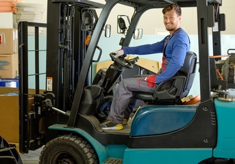 Man driving forklift truck on a warehouse