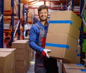Porter carrying boxes in a warehouse