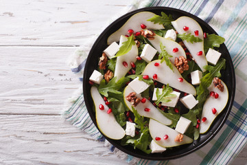 Pear salad with pomegranate, cheese and arugula. horizontal top view
