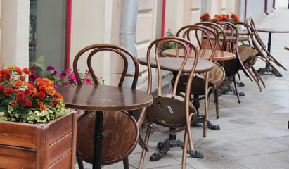 Street cafe with wooden tables and chairs and flowers. French style