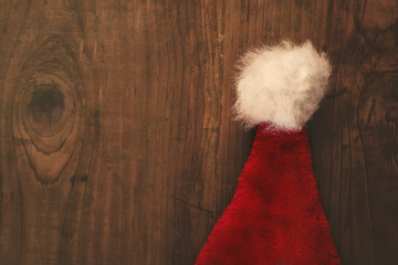 Obraz na płótnie Canvas Retro toned Santa Claus hat on wooden desk