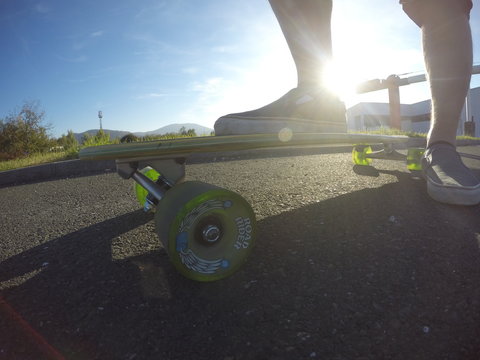 Longboard with male legs in the sun