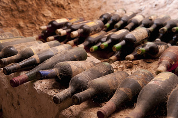 Old wine bottles on a stone step, a cave