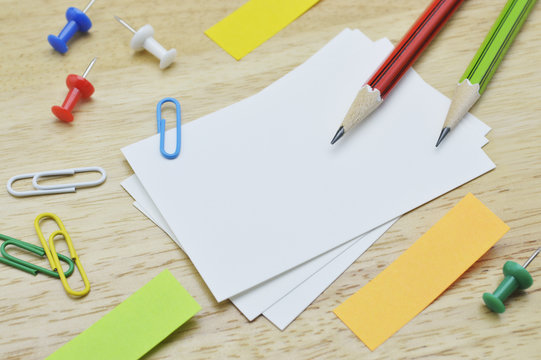 Namecard, pencil, clip and sticky notes on table